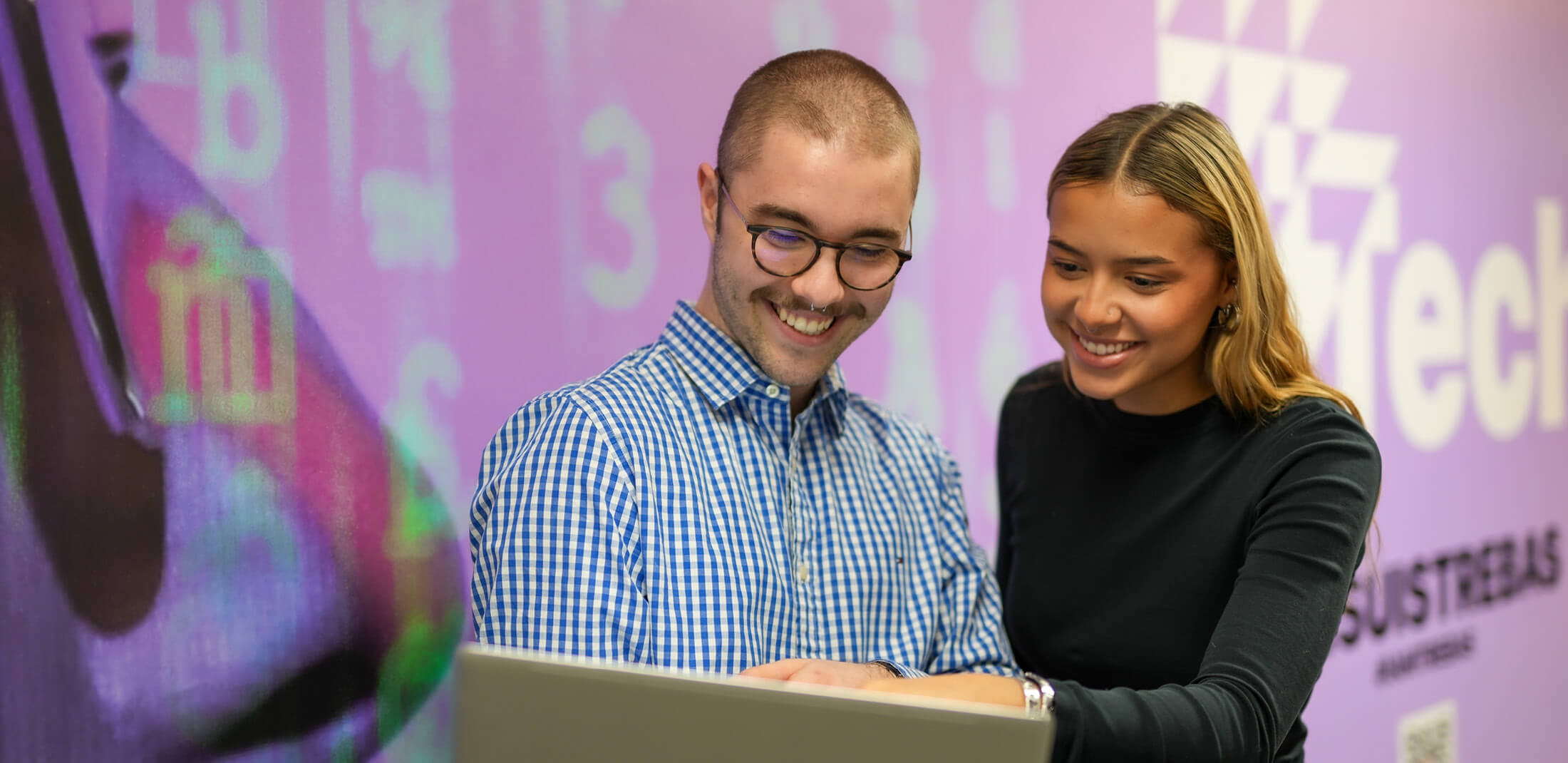 happy students looking at a laptop screen