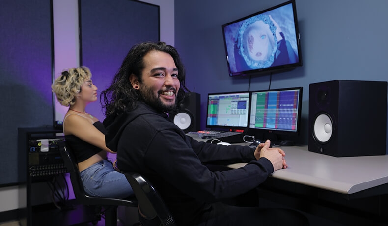 a student smiling inside a studio room