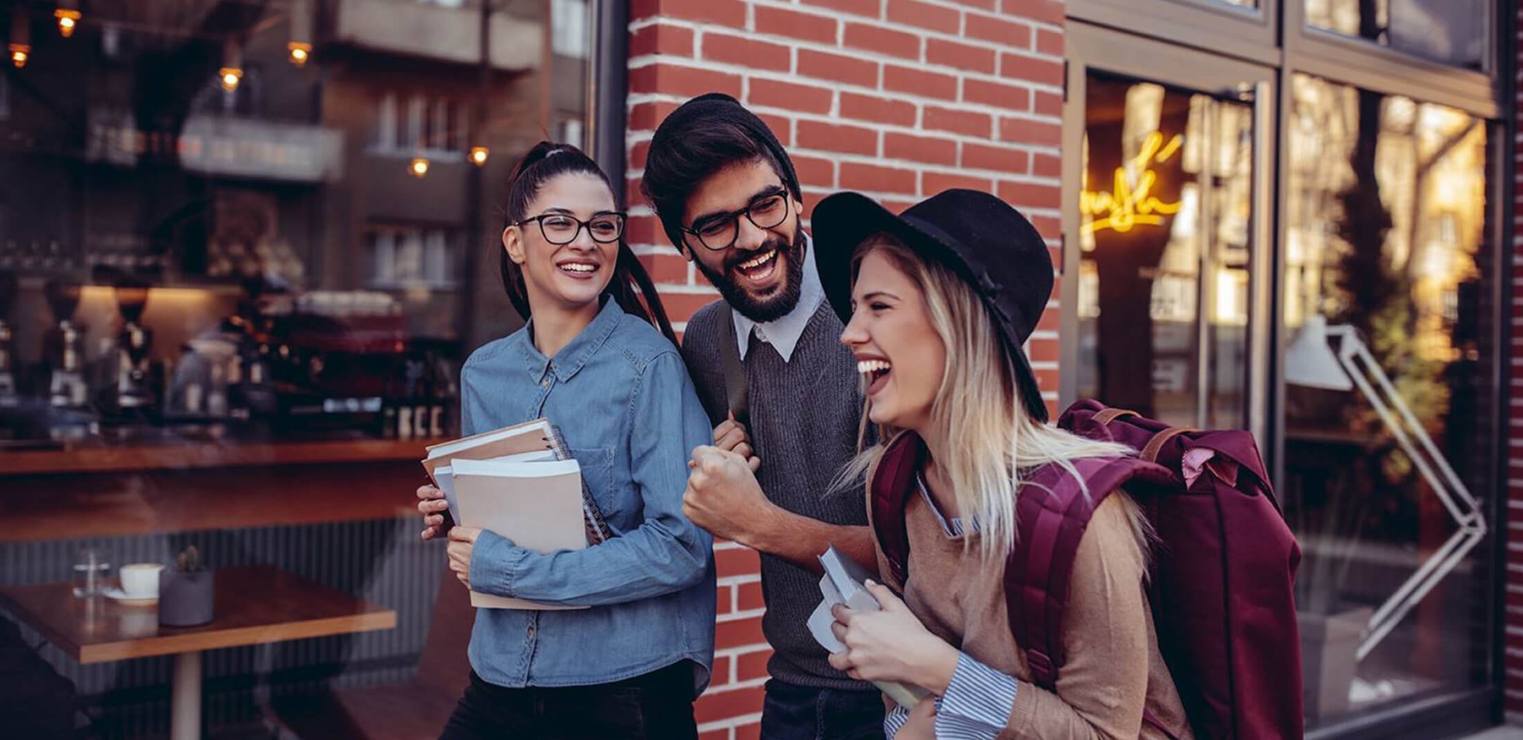 three students walking on a street and chatting