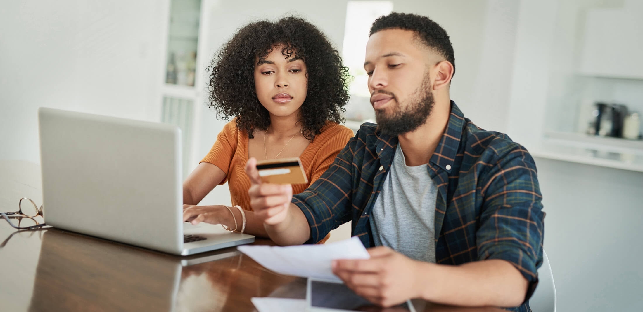 two people making an online payment and looking at a credit card